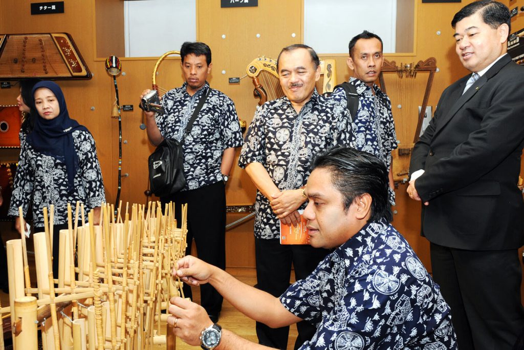 A member of institute plays an Indonesian Angklung on display in the Music Museum